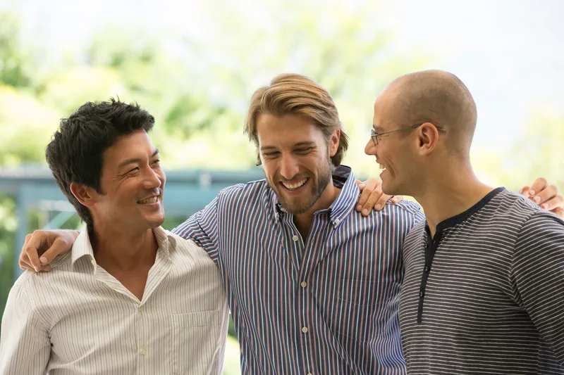 Three men laughing together